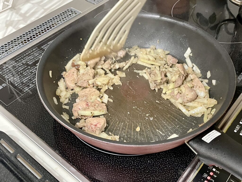 レバーと玉ねぎをフライパンで炒めている様子