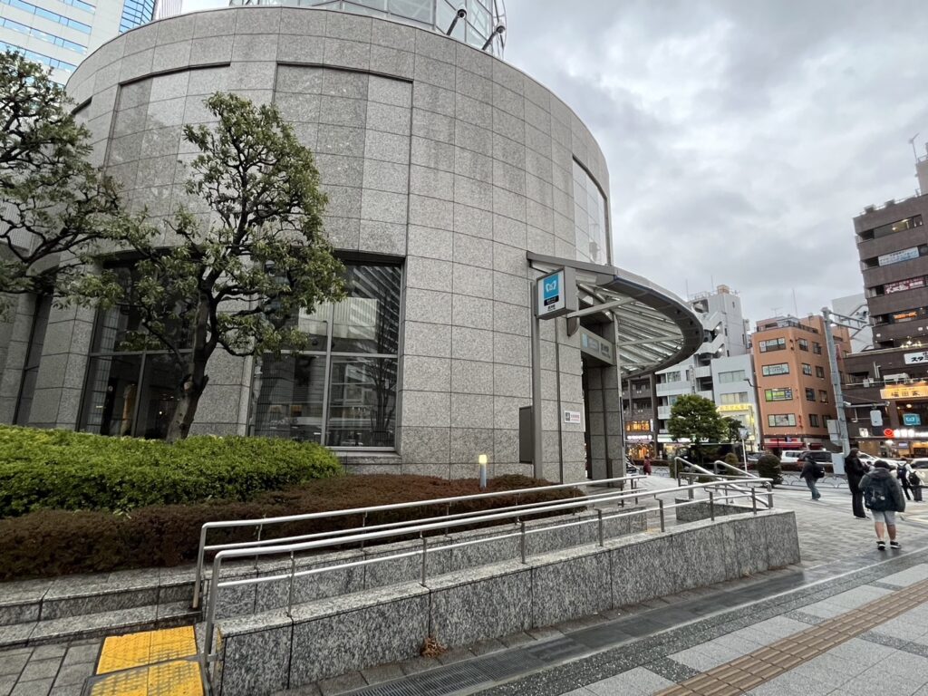 豊洲駅3番出口が入る円形ビル外観と周辺の歩道を写した写真