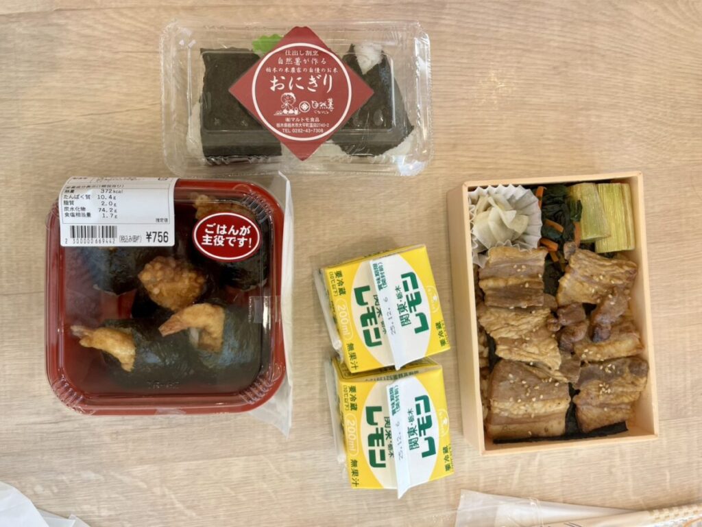 佐野SA上りで購入した天むす弁当、豚焼肉弁当、おにぎりとレモン牛乳。大人2人と幼児が30分滞在でシェアして食べた実際のメニュー例