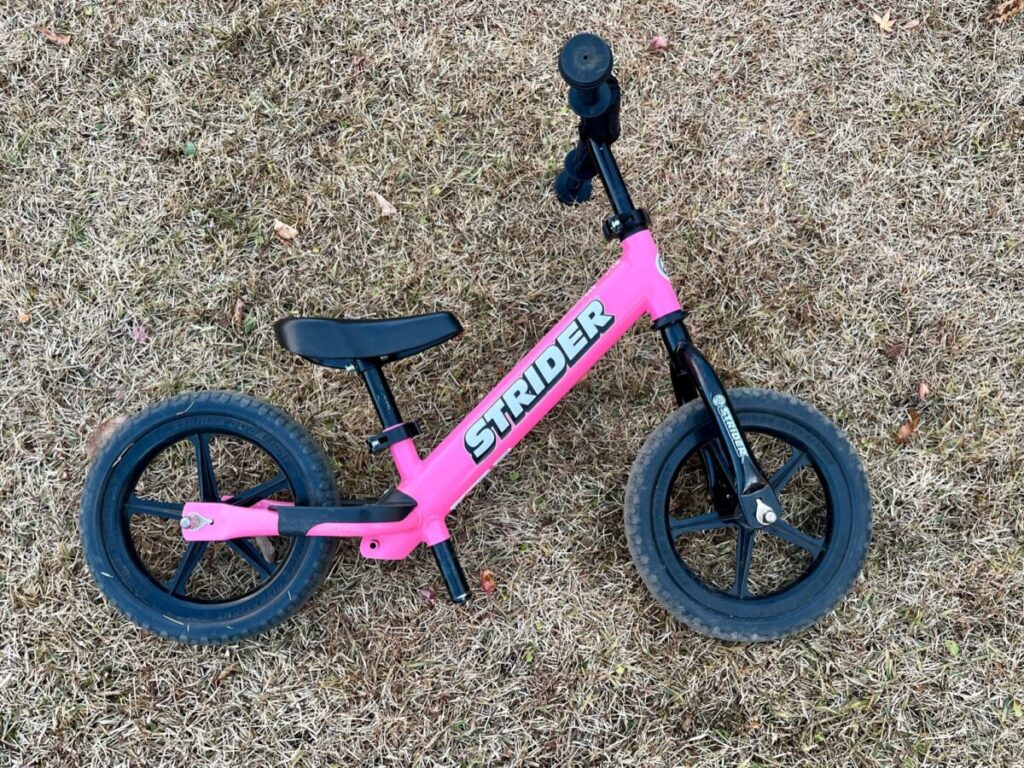 STRIDER 12 Sport ピンクの全体写真。軽量フレームと足乗せステップが見える。