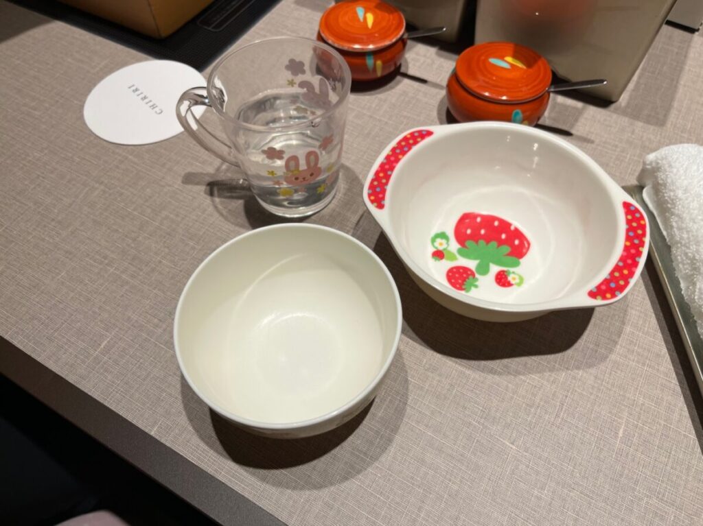 子ども用のプラスチック食器とコップが用意されたテーブル