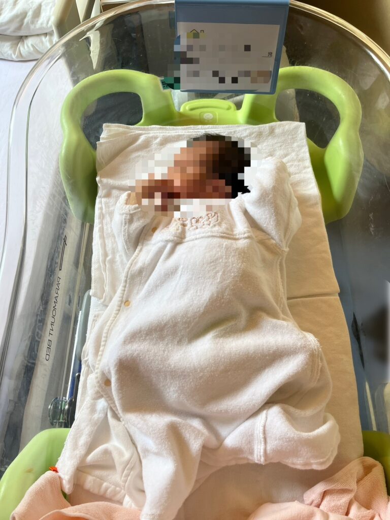 聖路加国際病院のコットに寝ている新生児のようす