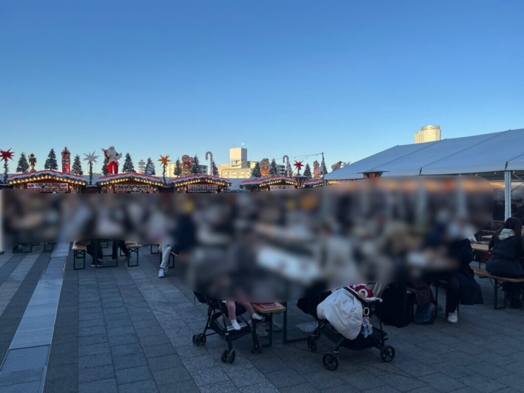 平日午後の飲食エリア。ベビーカーの家族連れが多く、席は半分ほど埋まっている様子。